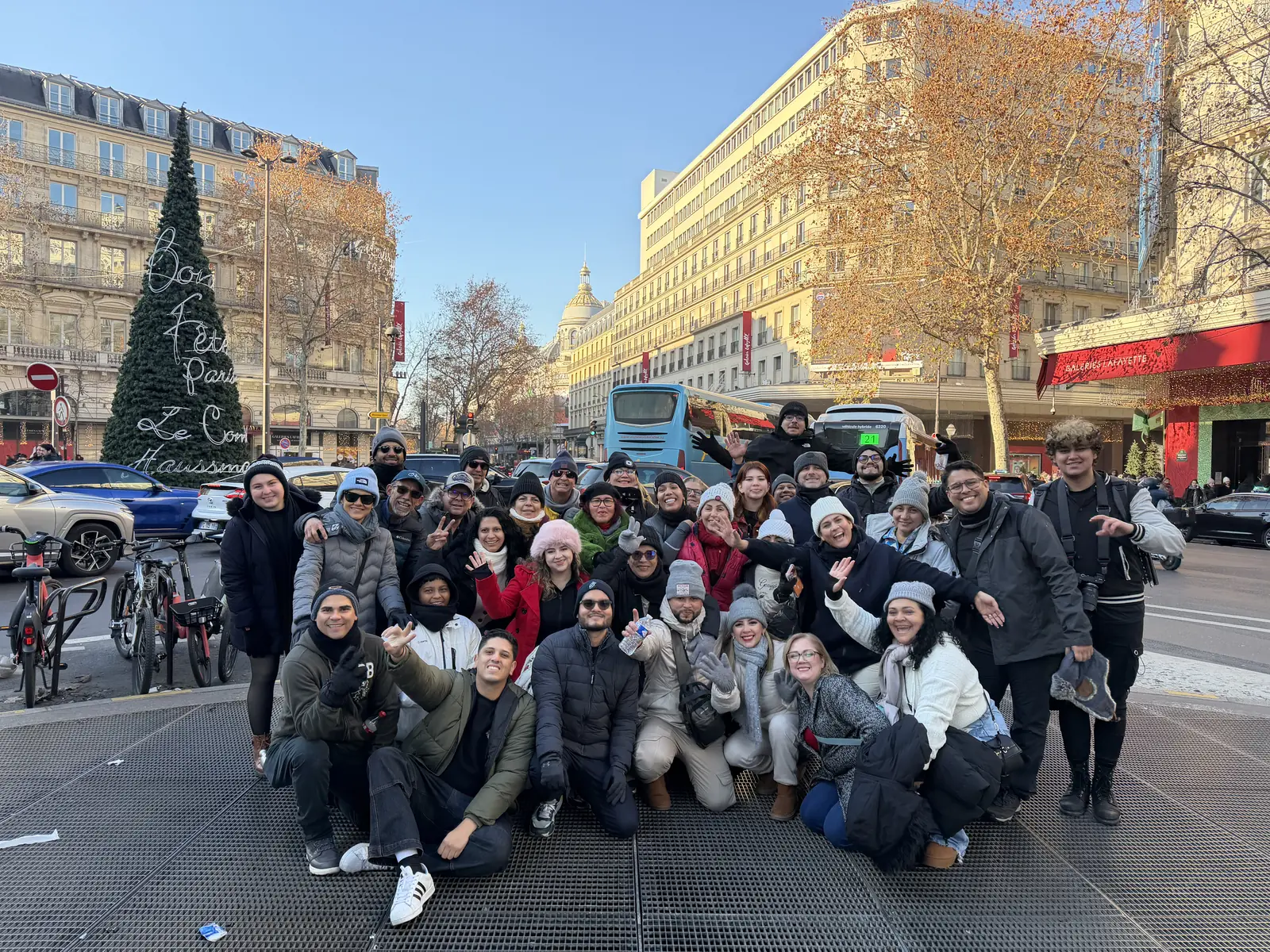 Grupo con un árbol de Navidad en una avenida de París