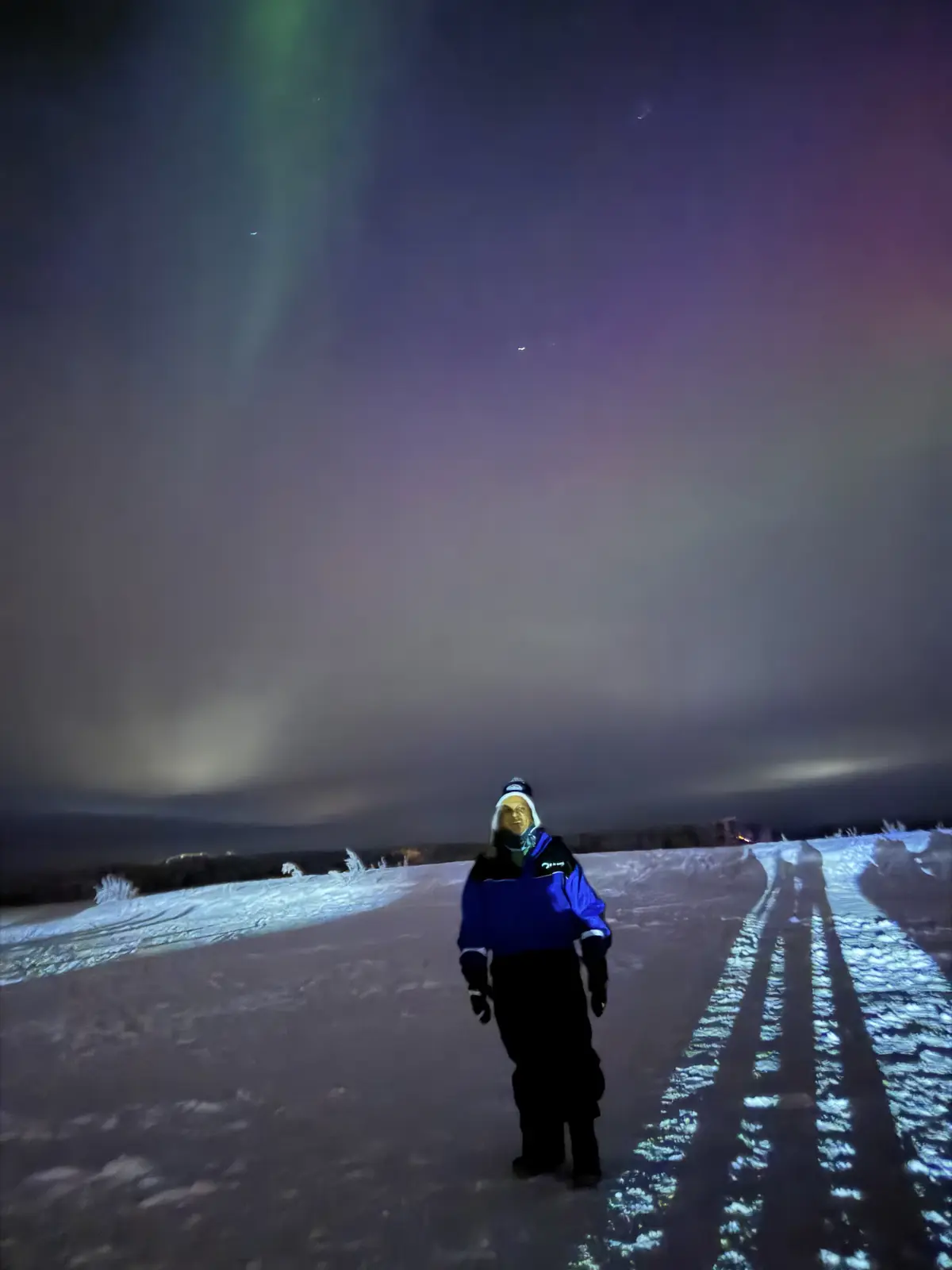 Viajero entre huellas en la nieve bajo la aurora