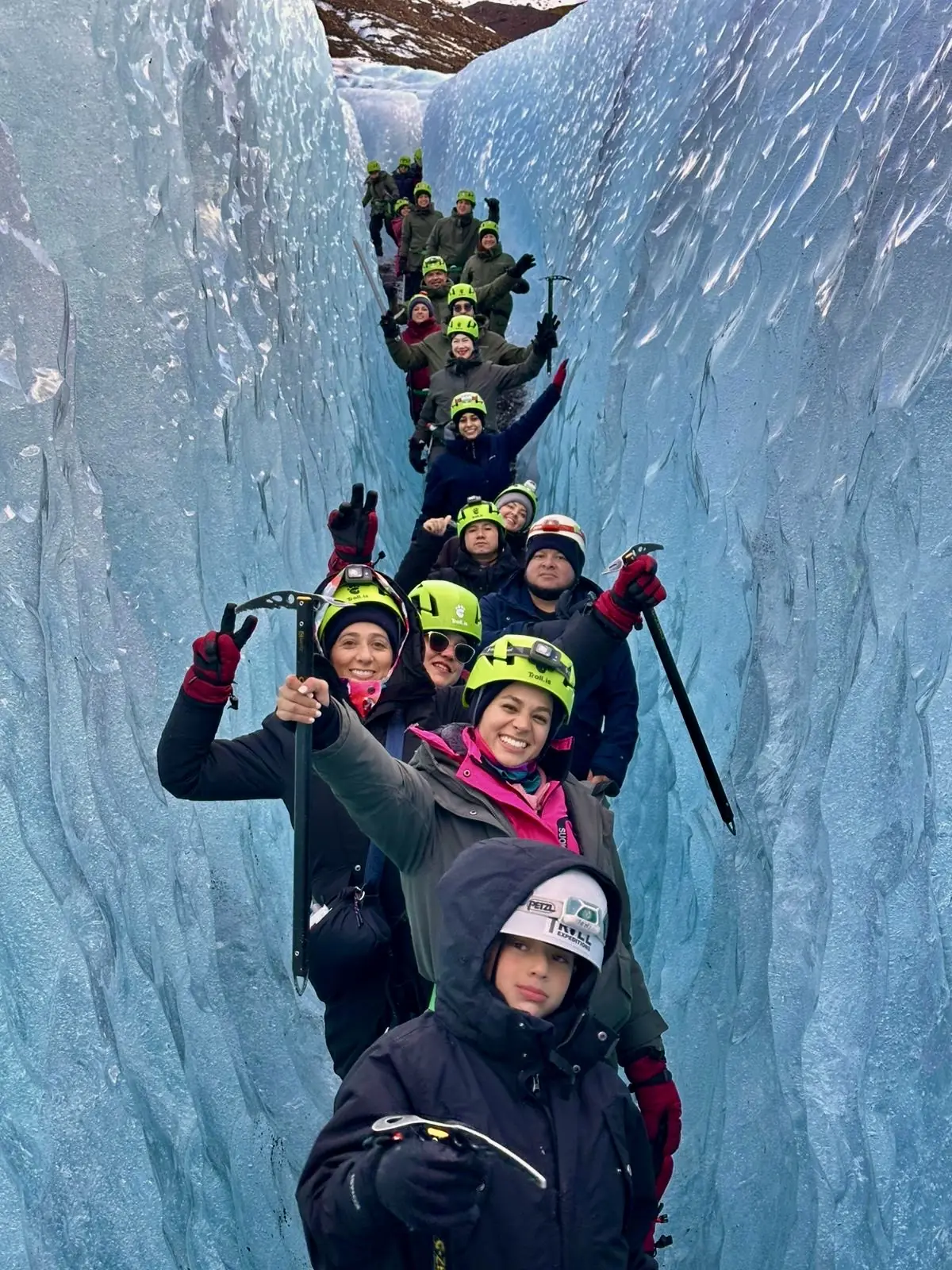 Viajeros con cascos dentro de una grieta de hielo azul